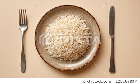 Plate of White Rice with Cutlery on Neutral Background 129165897