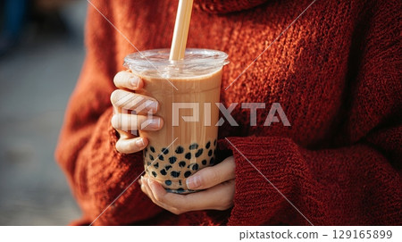 Woman Holding Bubble Tea in Cozy Sweater 129165899