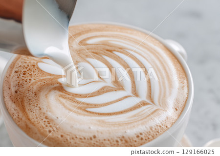 Creamy Milk Poured into Cup of Coffee Creating Beautiful Art on Surface of Beverage Creamy Milk Poured into Cup of Coffee Creating Beautiful Art on Surface of Beverage 129166025