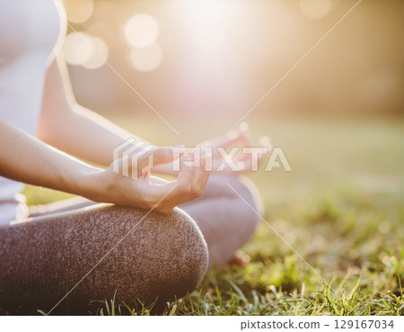 Woman meditating in the garden early in the morning Woman meditating in the garden early in the morning 129167034