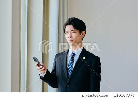 A young lawyer in his twenties operating a smartphone A young lawyer in his twenties operating a smartphone 129167375