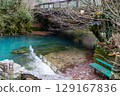 Small blue lake surrounded by mountains with clear water 129167836