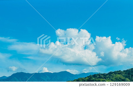 Summer blue sky, white clouds and mountain range 129169009