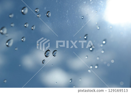 water drop on mirror with blue sky and white cloud background water drop on mirror with blue sky and white cloud background 129169513