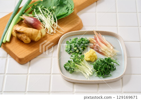 Assorted chopped condiments: ginger, myoga, shiso leaves, green onions, and daikon radish 129169671