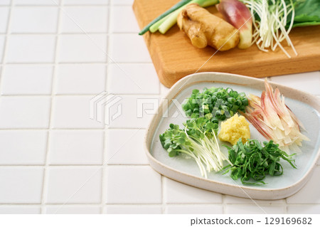 各種切碎的調味品:生薑、茗荷、紫蘇葉、蔥和蘿蔔 各種切碎的調味品:生薑、茗荷、紫蘇葉、蔥和蘿蔔 129169682