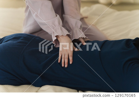 一位年輕女子正在按摩一位年輕男子的下背部 生活方式圖片 一位年輕女子正在按摩一位年輕男子的下背部 生活方式圖片 129170165