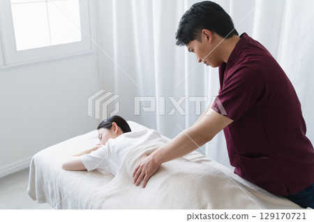 一位年輕女子正在接受脊椎按摩師的按摩 美容形象 129170721