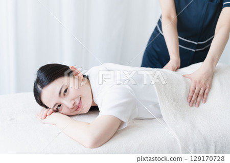 Young woman receiving massage from therapist Beauty image Young woman receiving massage from therapist Beauty image 129170728