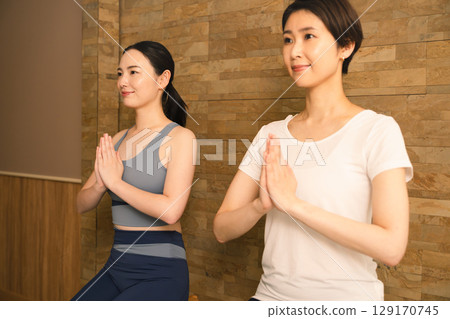 Two young women doing hot yoga. Beauty image. 129170745