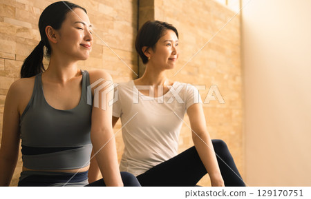 Two young women doing hot yoga. Beauty image. 129170751