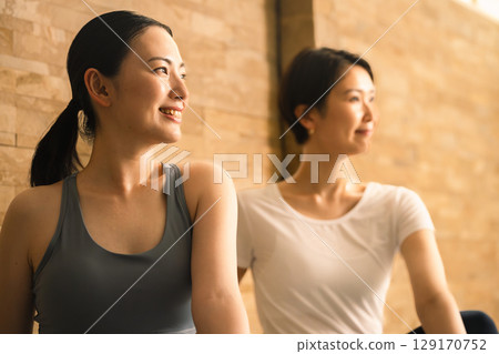 Two young women doing hot yoga. Beauty image. 129170752
