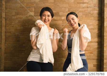 Two young women wiping sweat with a towel Beauty image 129170760