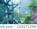 The moment when the gondola of the Gozaisho Ropeway in Mie Prefecture passes through the green support pillar, with Yunoyama Onsen visible below [July] 129171296