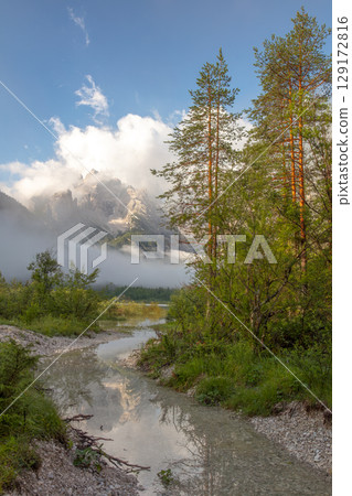 Misty Mountain Peaks Reflected in Alpine Creek with Pine Forest Misty Mountain Peaks Reflected in Alpine Creek with Pine Forest 129172816