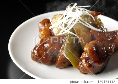 Hot sweet and sour pork with black vinegar photographed against a black background Hot sweet and sour pork with black vinegar photographed against a black background 129173432