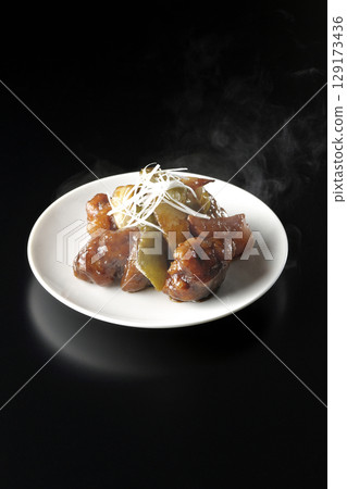 Hot sweet and sour pork with black vinegar photographed against a black background Hot sweet and sour pork with black vinegar photographed against a black background 129173436