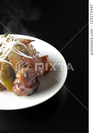 Hot sweet and sour pork with black vinegar photographed against a black background Hot sweet and sour pork with black vinegar photographed against a black background 129173447