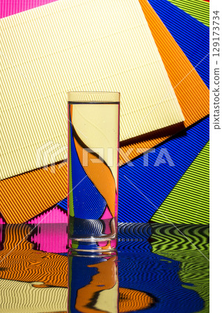 Abstract still life with a glass of water on a color bright background Abstract still life with a glass of water on a color bright background 129173734