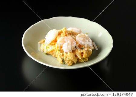 Chinese stir-fried shrimp and eggs photographed against a black background 129174047