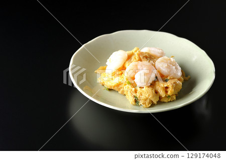 Chinese stir-fried shrimp and eggs photographed against a black background Chinese stir-fried shrimp and eggs photographed against a black background 129174048