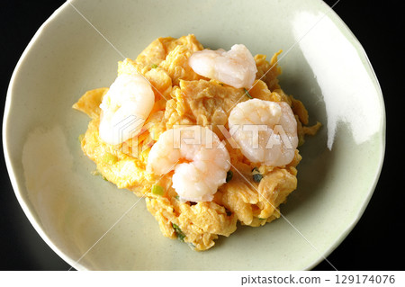 Chinese stir-fried shrimp and eggs photographed against a black background 129174076