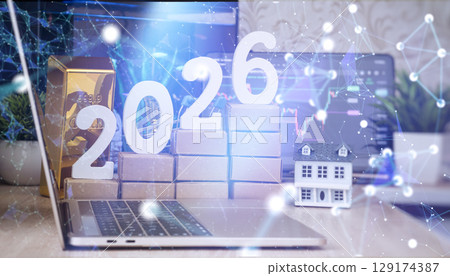Laptop with 2026 numbers, gold bar, house model, and digital network overlay, representing future investment and wealth trends in technology. Laptop with 2026 numbers, gold bar, house model, and digital network overlay, representing future investment and wealth trends in technology. 129174387