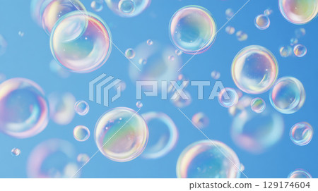 floating iridescent bubbles with thin rainbow edges over silky blue backdrop with scattered suds 129174604