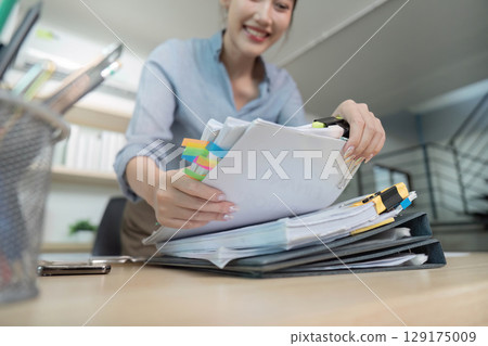 Office Worker Organizing Documents with Colorful Tabs 129175009