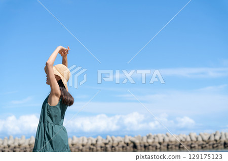 站在藍色大海中的年輕女子 站在藍色大海中的年輕女子 129175123