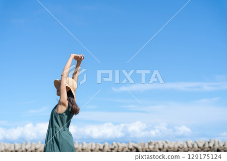 Young woman standing in the blue sea 129175124