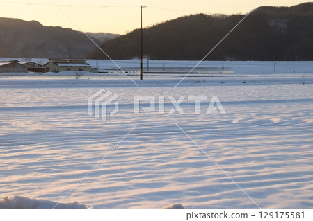 Snowfield lit by the setting sun Snowfield lit by the setting sun 129175581