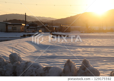 Snowfield lit by the setting sun Snowfield lit by the setting sun 129175592
