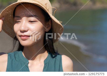 Close-up of a young woman standing in the blue sea 129175773