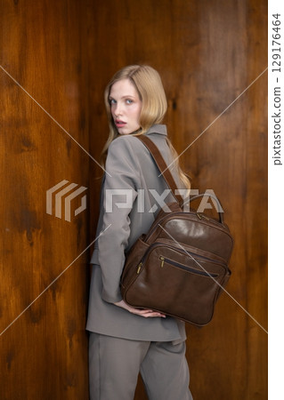 A stylish young woman, long blonde hair, poses in a grey suit, h A stylish young woman, long blonde hair, poses in a grey suit, h 129176464