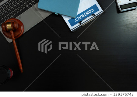 Justice and law concept.Lawyer workplace with laptop and documents with dark wooden in office. Justice and law concept.Lawyer workplace with laptop and documents with dark wooden in office. 129176742
