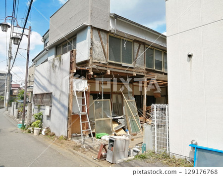 Old wooden house being demolished 129176768