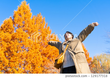 Woman enjoying autumn leaves lifestyle image Woman enjoying autumn leaves lifestyle image 129177318