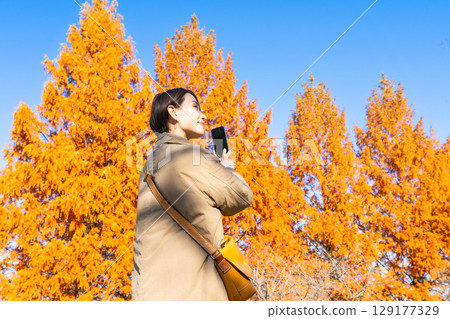 一位女士用智慧型手機拍攝秋葉照片 生活風格影像 一位女士用智慧型手機拍攝秋葉照片 生活風格影像 129177329
