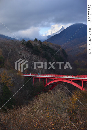Autumnal Yatsugatake: Red iron bridge and autumn leaves 129177722