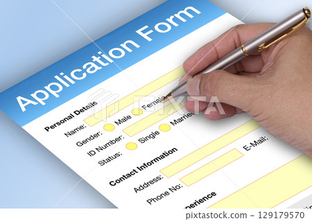 Hand holding pen to writting application form. 129179570