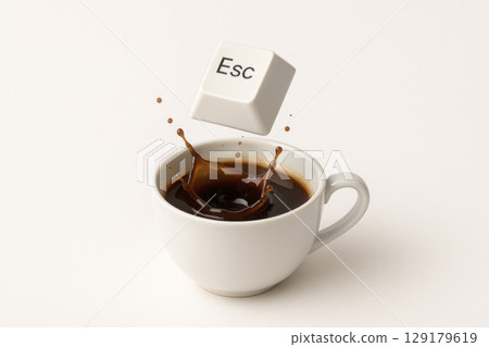 Esc button falling into a cup of coffee with a splash on a white background. Space for text. Esc button falling into a cup of coffee with a splash on a white background. Space for text. 129179619