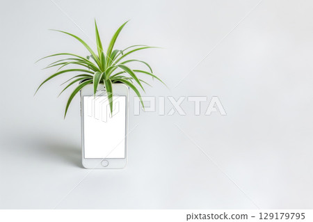 A smartphone with a plant growing out of a screen. Space for text. 129179795