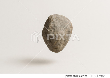 A stone floating in the air on a light background. Space for text. 129179850