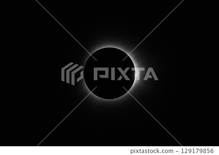 A bright solar eclipse with a shining crown on a black background. Space for text. A bright solar eclipse with a shining crown on a black background. Space for text. 129179856