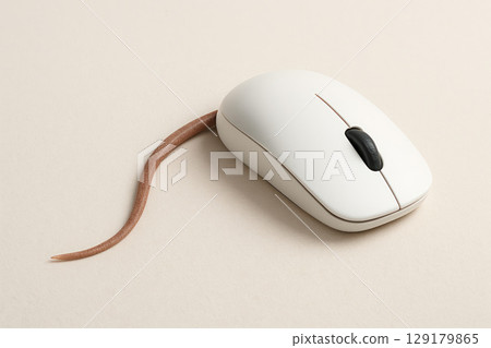Computer mouse with the tail of a real mouse on a light background. Space for text. 129179865