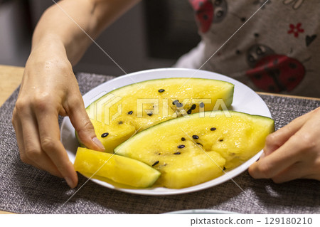 Close up shot of the cut watermelon with yellow flesh on ceramic plate Close up shot of the cut watermelon with yellow flesh on ceramic plate 129180210