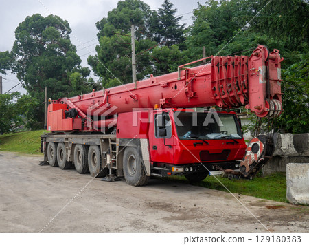 Heavy construction equipment in the parking lot. mobile crane. Red faucet. Out of work. Heavy construction equipment in the parking lot. mobile crane. Red faucet. Out of work. 129180383