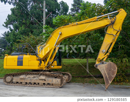 Heavy construction equipment in the parking lot. Bucket excavator. Yellow heavy car. Construction equipment. Out of work. 129180385