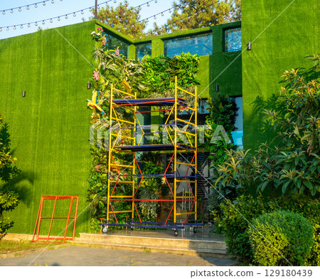 Facade of the building in green matter. Preparations for decorative work. Building reconstruction. Beautiful facade. Facade of the building in green matter. Preparations for decorative work. Building reconstruction. Beautiful facade. 129180439